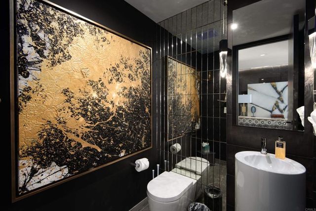 a bathroom with a toilet sink and mirror