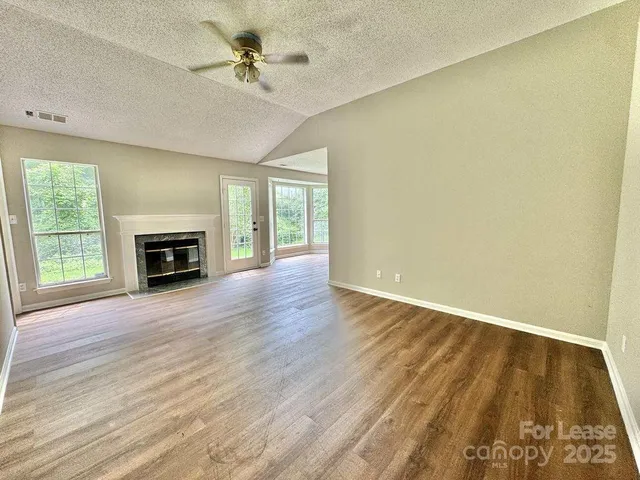 a view of an empty room with a fireplace and a window