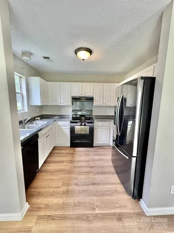 a large kitchen with a stove a refrigerator and a sink
