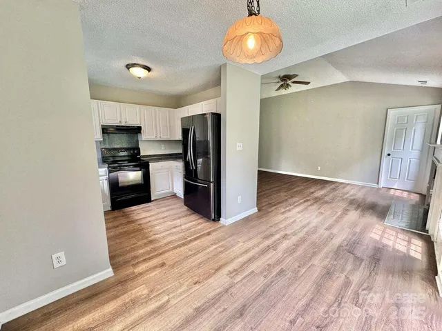 a view of a kitchen with a sink and a refrigerator