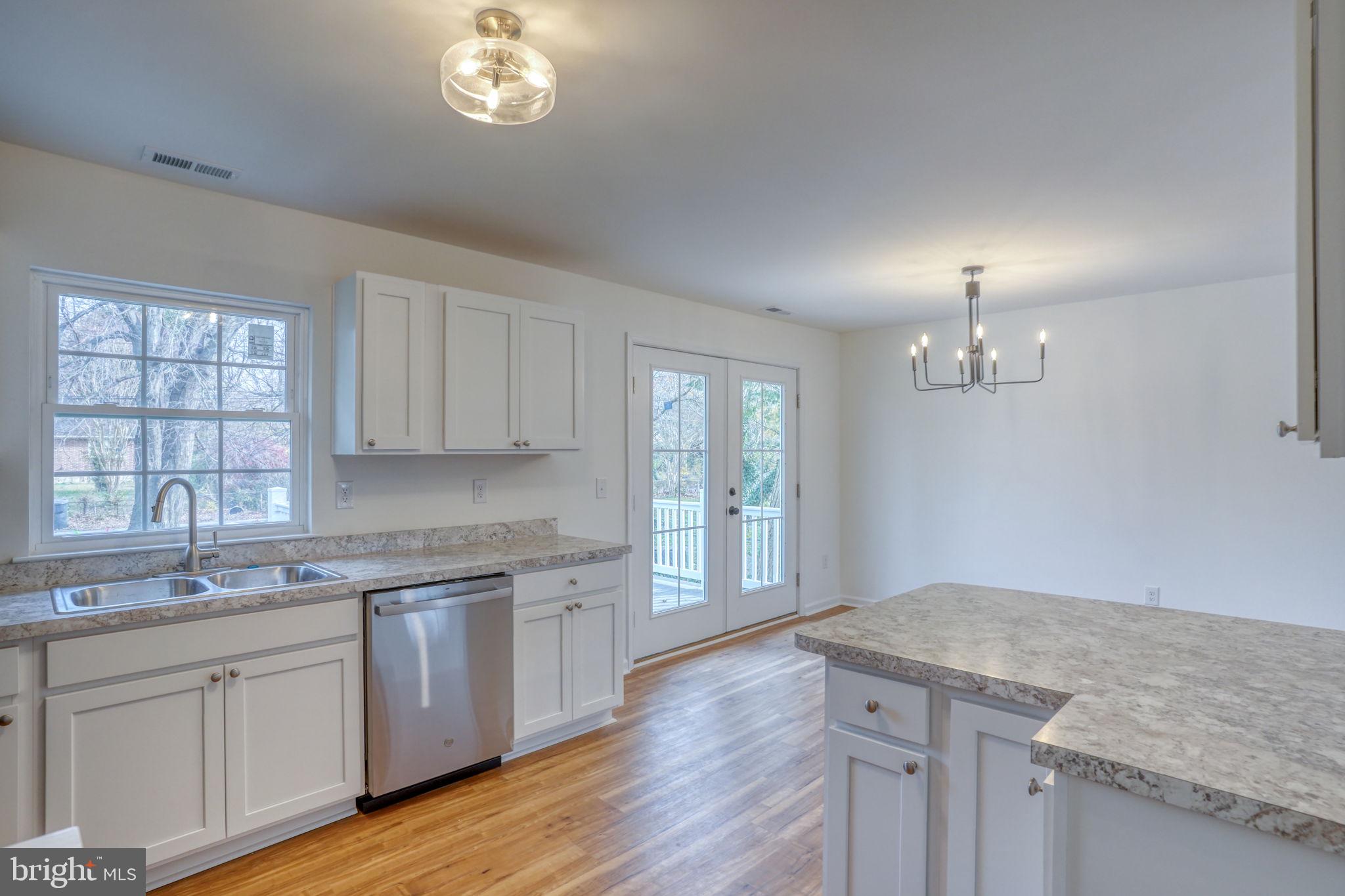 811 Sunset Terrace Dover, DE 19904 - Photo 11 of 45 a kitchen with granite countertop white cabinets and a wooden floor