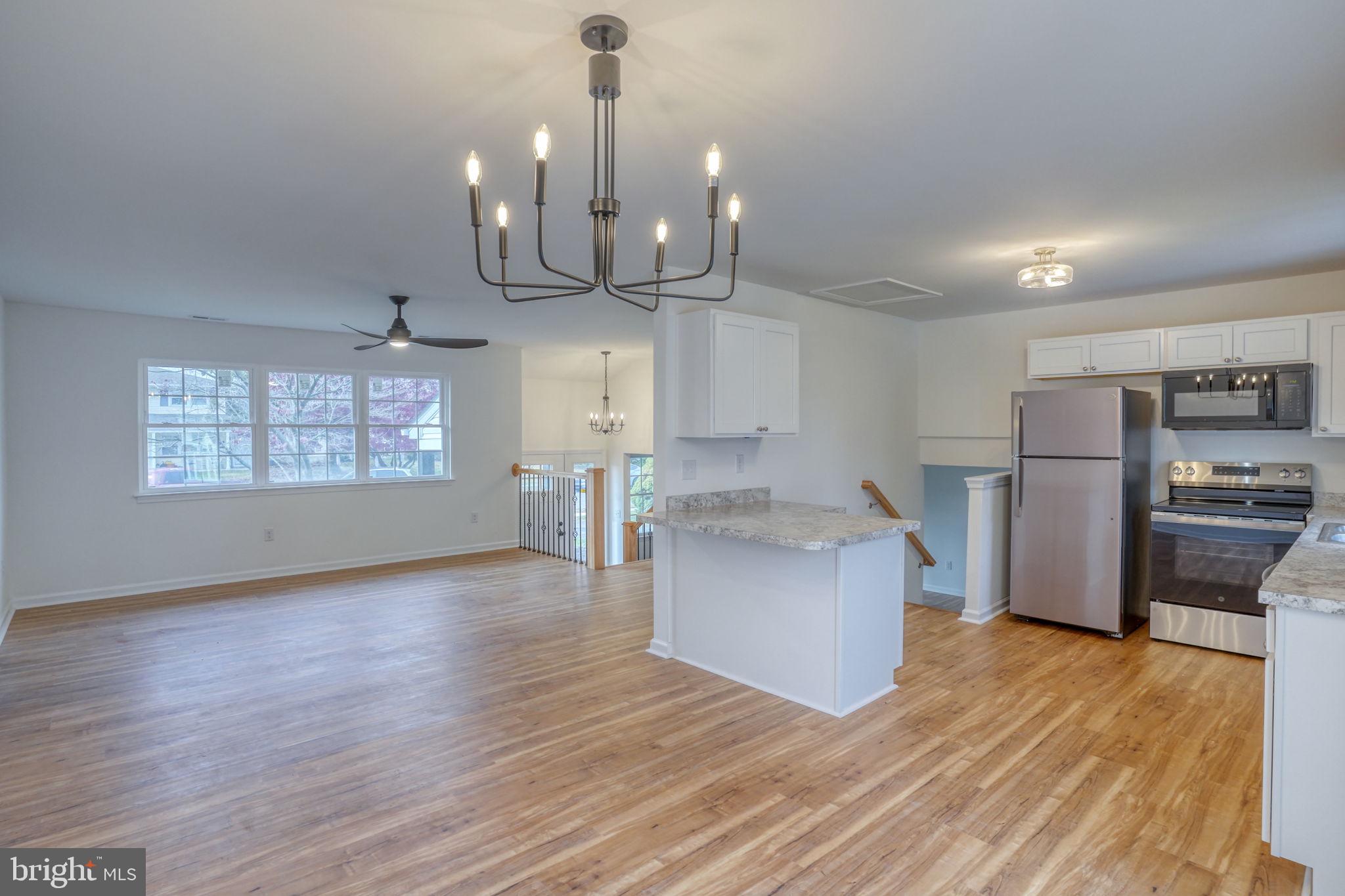 811 Sunset Terrace Dover, DE 19904 - Photo 13 of 45 a open kitchen with stainless steel appliances granite countertop a sink a stove a refrigerator and island with wooden floor