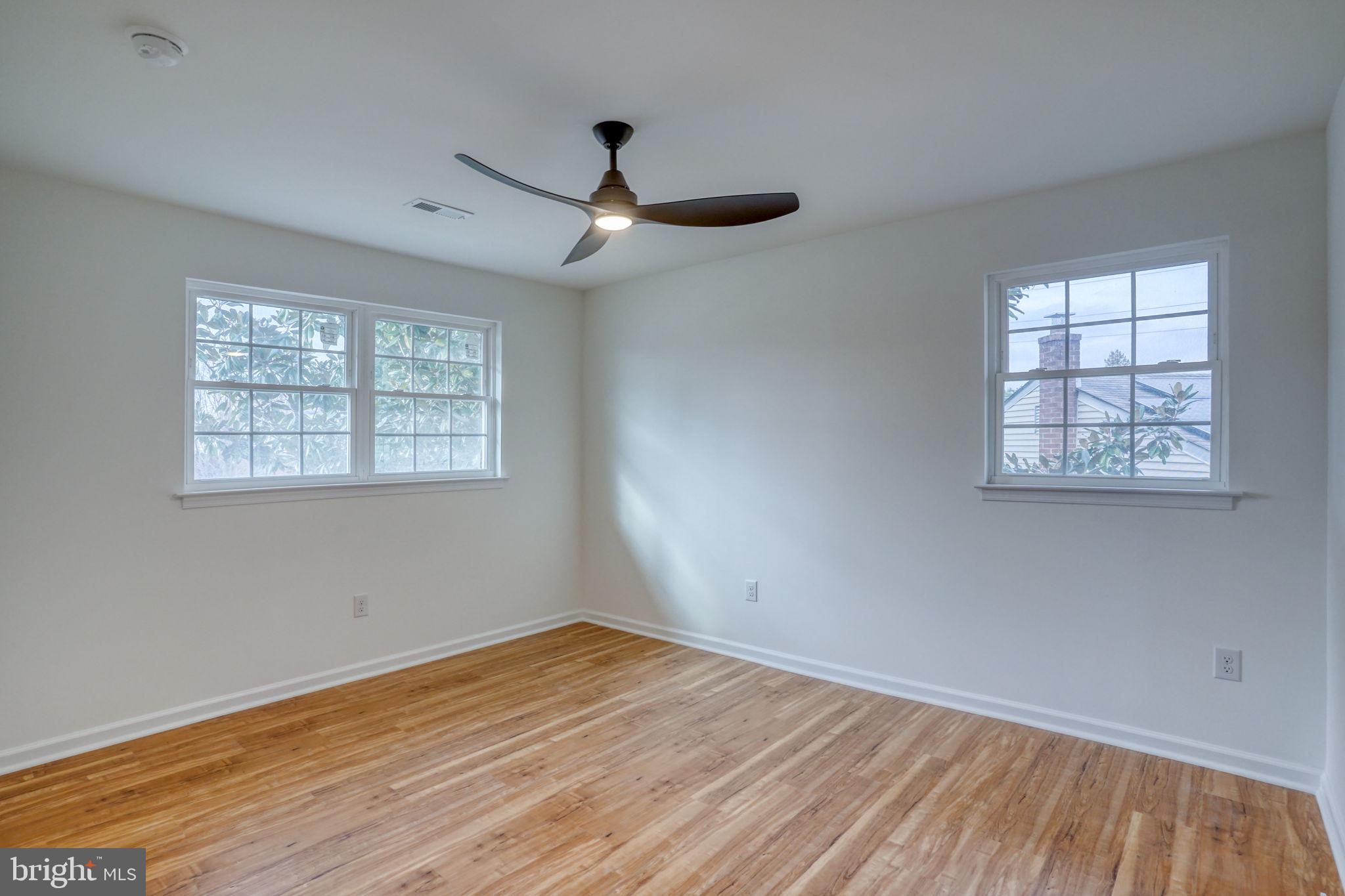 811 Sunset Terrace Dover, DE 19904 - Photo 28 of 45 an empty room with wooden floor ceiling fan and windows