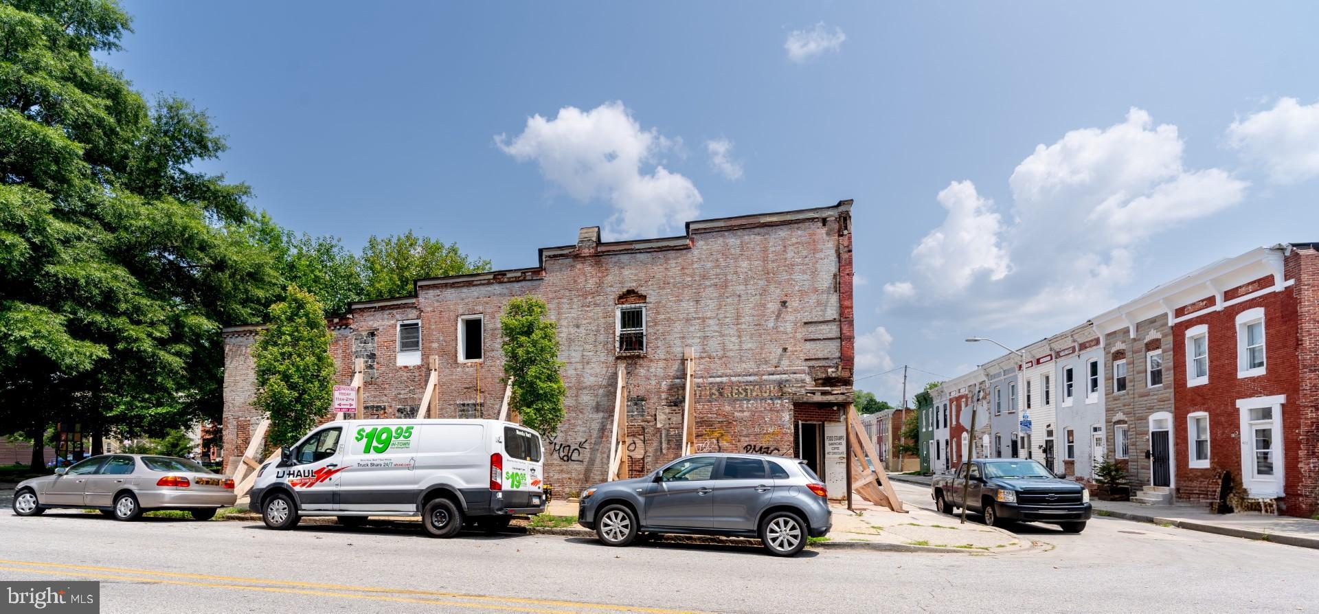 400-402 Pitman Place Baltimore, MD 21202 - Photo 2 of 11 a view of road with card parked on side and retail shops