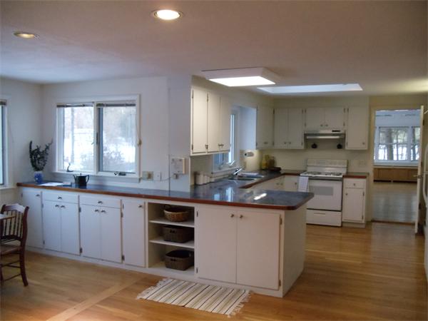 a large kitchen with cabinets and wooden floor