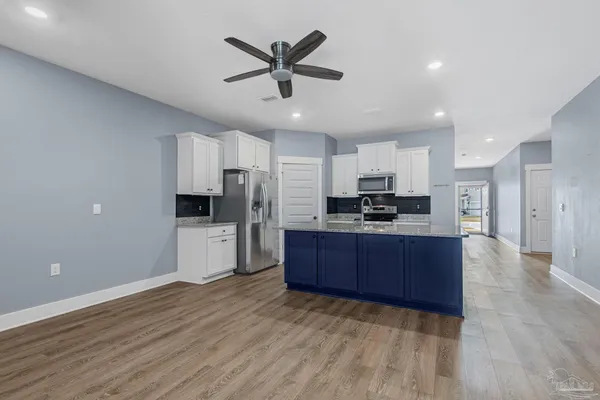 a kitchen with stainless steel appliances a refrigerator and a stove top oven