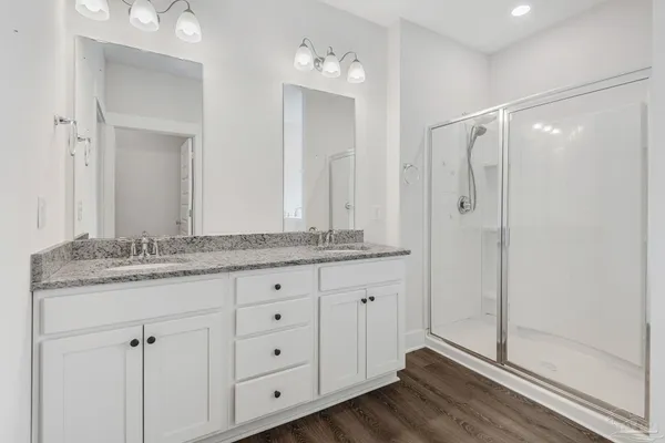 a bathroom with a granite countertop shower sink and mirror