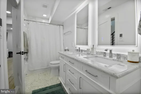 a bathroom with a granite countertop sink a toilet and a shower