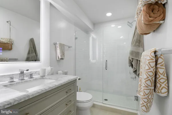 a bathroom with a granite countertop sink a toilet and shower