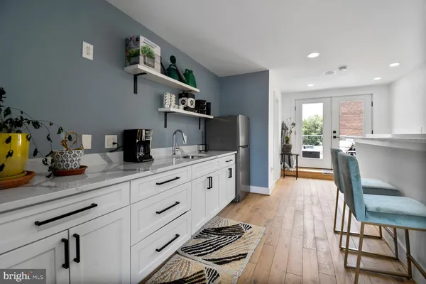 a kitchen with stainless steel appliances kitchen island granite countertop a sink cabinets and wooden floor