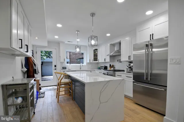 a kitchen with kitchen island a refrigerator a sink and wooden floor