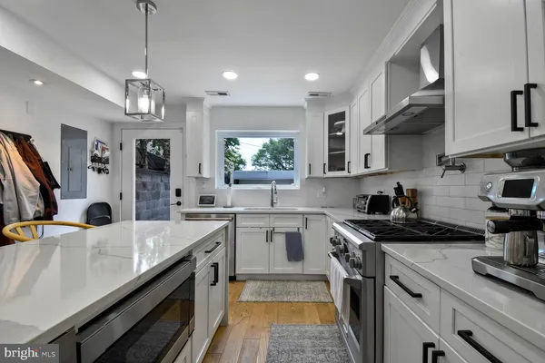 a kitchen with stainless steel appliances a sink stove and cabinets