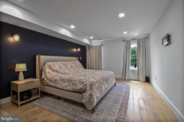 a spacious bedroom with a bed and a wooden floor