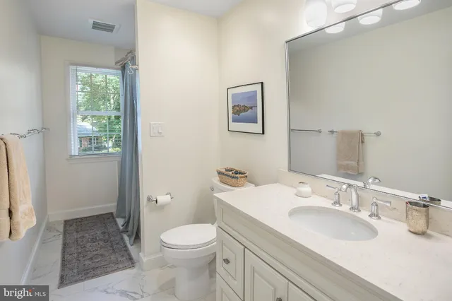 a bathroom with a granite countertop sink toilet and shower