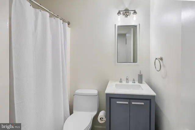 a bathroom with a toilet a sink and a mirror