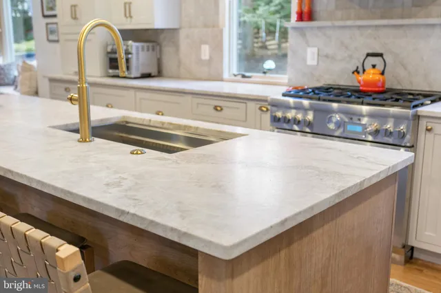 a kitchen with a stove and a sink with wooden floor