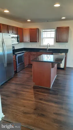 a kitchen with stainless steel appliances wooden cabinets a refrigerator and a stove