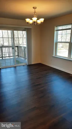 a view of a room with wooden floor and large windows