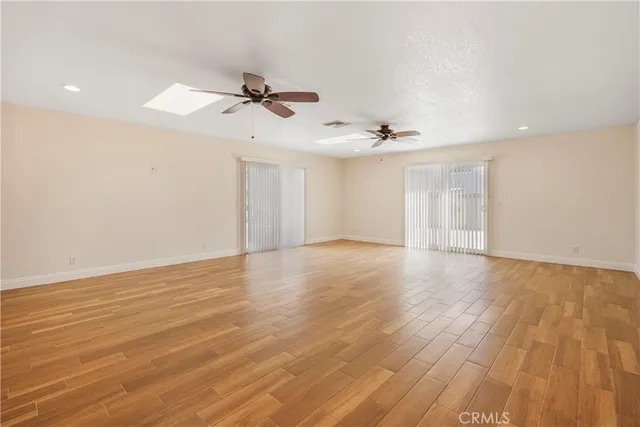 a view of a room with wooden floor and ceiling fan