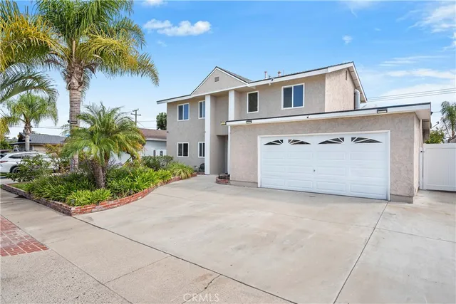 a view of a house with a yard and palm trees