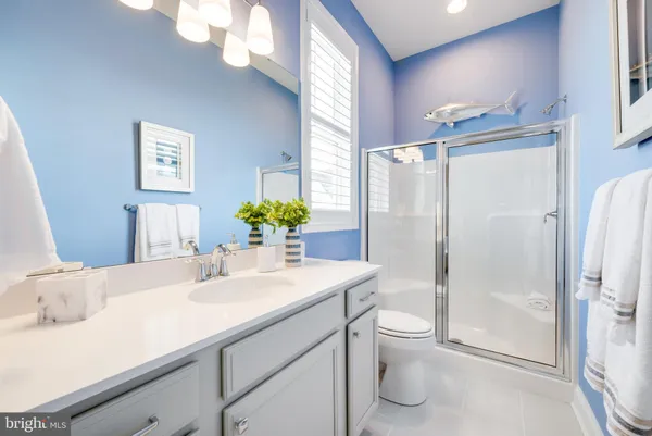 a bathroom with a granite countertop sink a toilet and shower