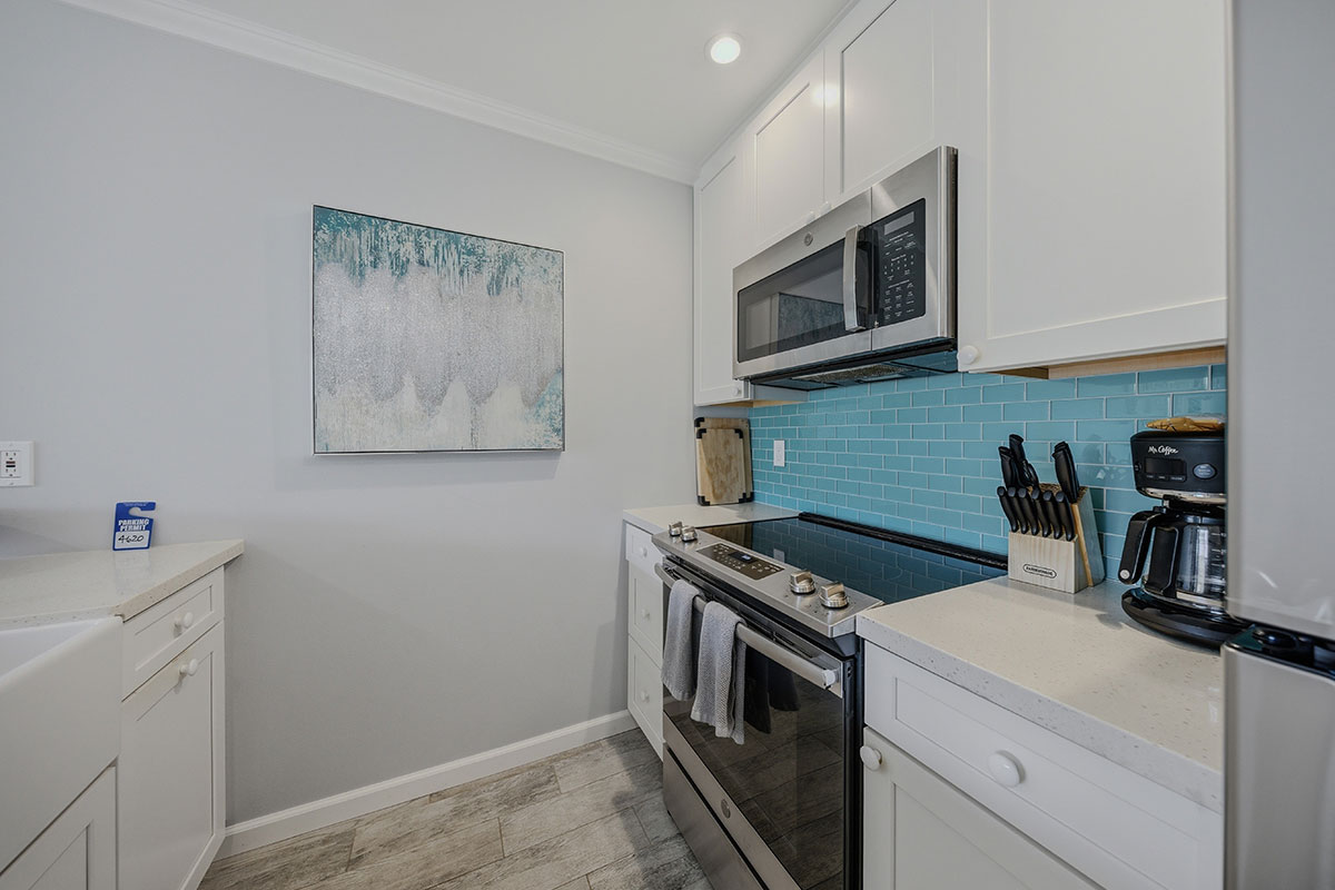 525 Aleka Loop, Unit J2 Kapaa, HI 96746 - Photo 3 of 30 a kitchen with white cabinets and stainless steel appliances