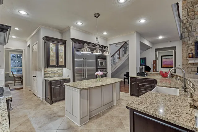 a view of kitchen with stainless steel appliances granite countertop a stove and a refrigerator