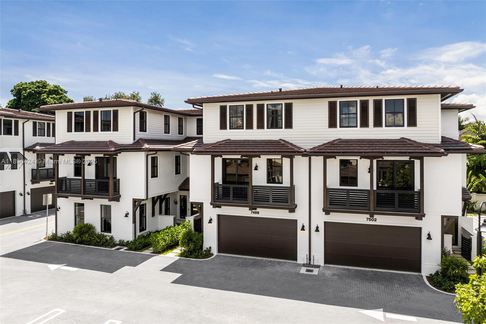 a front view of a residential apartment building with a yard and balcony