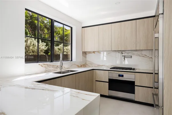 a kitchen with stainless steel appliances granite countertop a refrigerator a sink and white cabinets