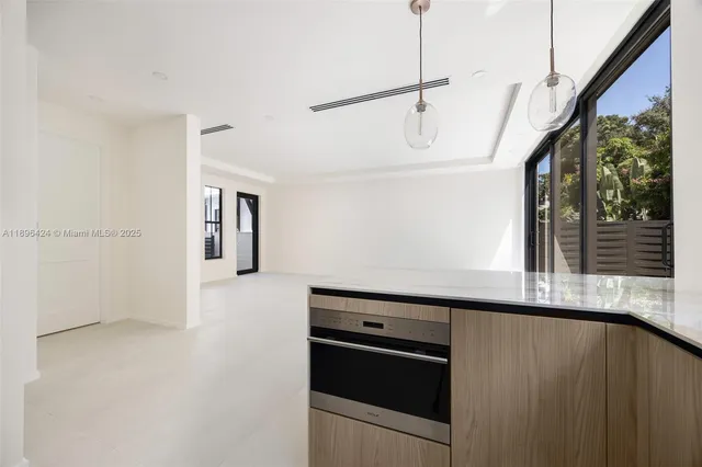 a kitchen with stainless steel appliances granite countertop a refrigerator a sink and white cabinets