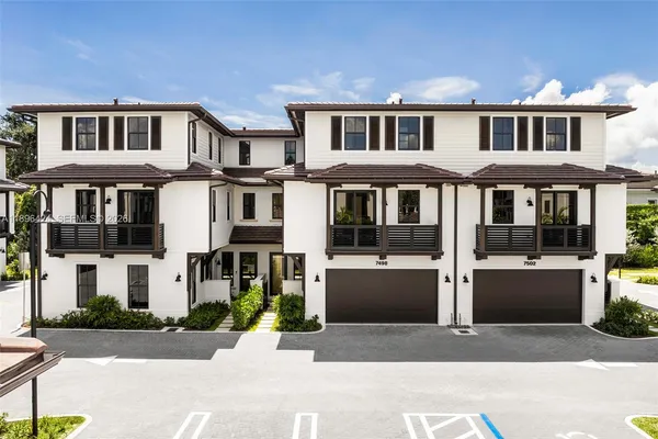 a front view of a residential apartment building with a yard and balcony