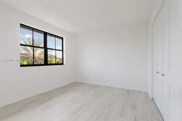 an empty room with windows and closet