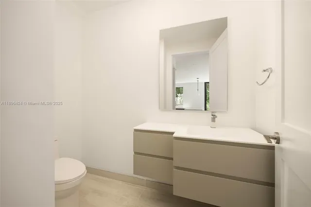 a bathroom with a granite countertop sink a toilet and shower