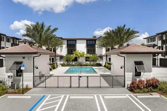 a view of a white building among the street with palm trees