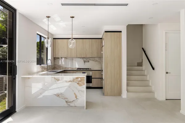 a view of a kitchen with refrigerator and more cabinets