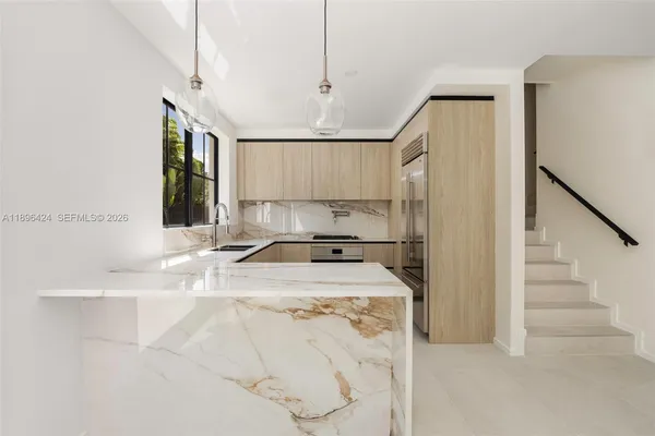 a kitchen with stainless steel appliances granite countertop a sink a stove and a refrigerator