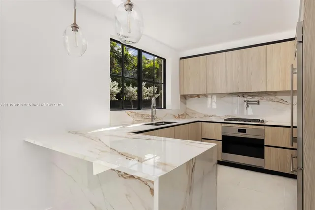 a kitchen with stainless steel appliances granite countertop a sink stove and refrigerator