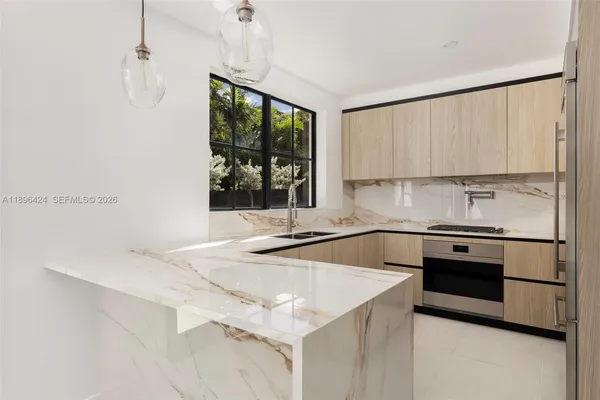 a kitchen with a stove a sink and a window