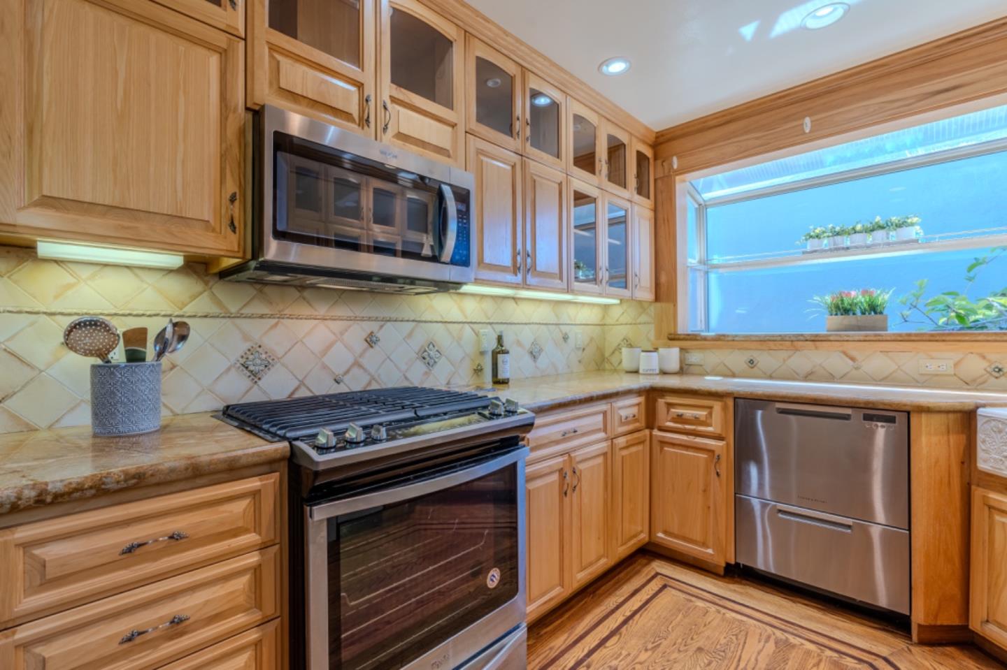 67 Cliffside Drive Daly City, CA 94015 - Photo 12 of 37 a kitchen with stainless steel appliances granite countertop a stove and a microwave