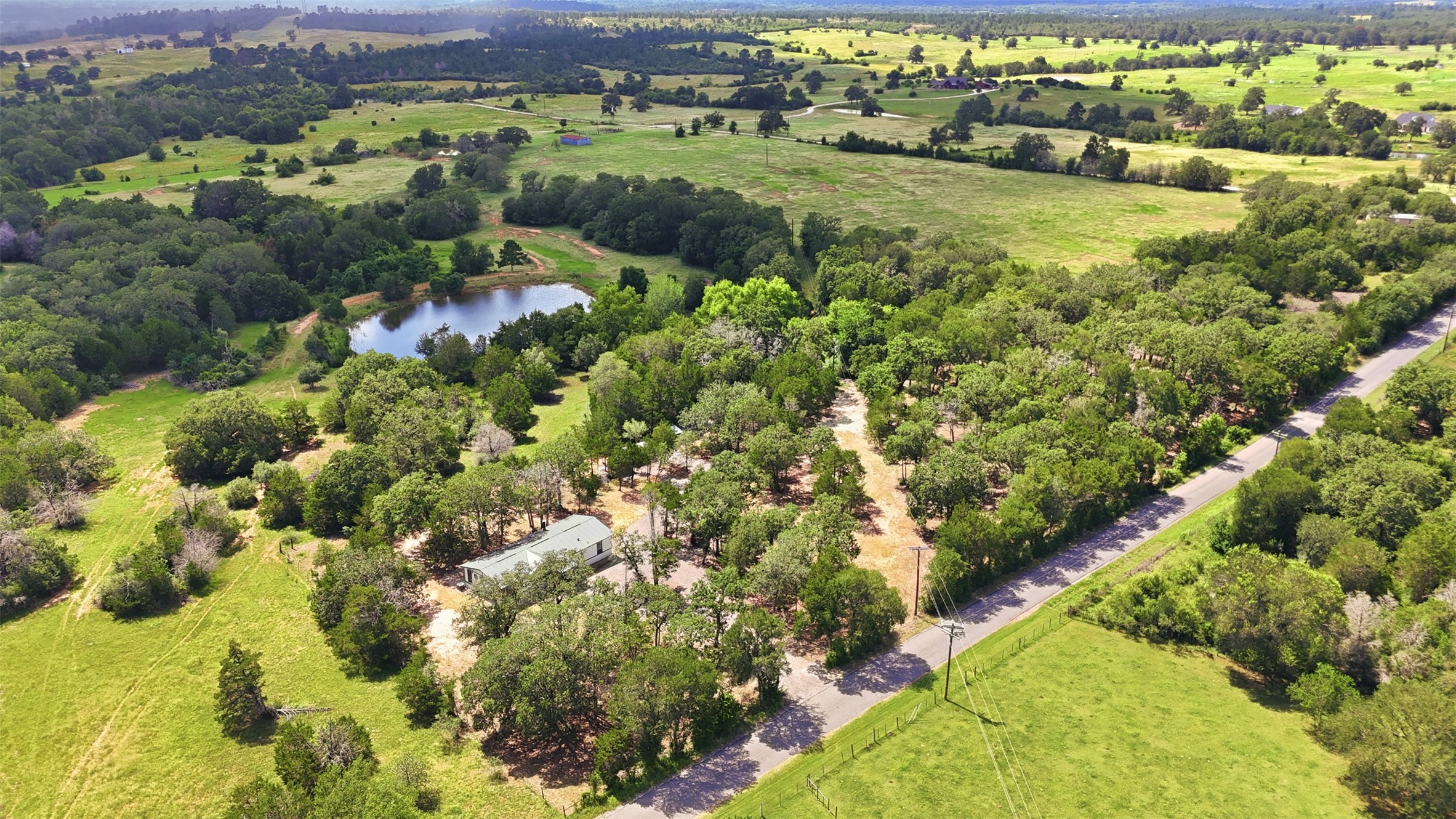 154 Antioch Road Smithville, TX 78957 - Photo 31 of 32 An aerial perspective reveals a secluded home nestled among trees. *Pond is not part of this property*