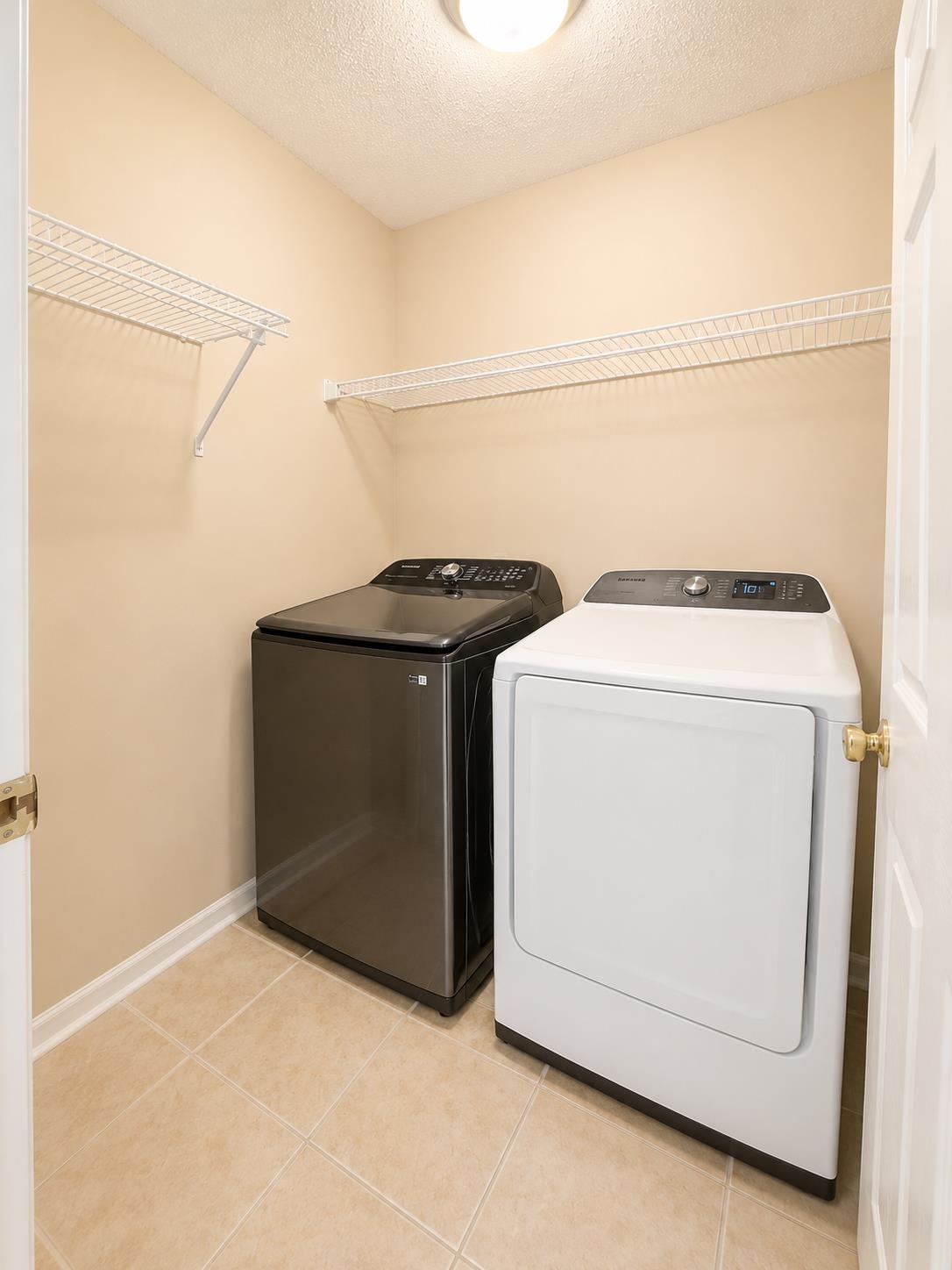 326 South Sanga Road Cordova, TN 38018 - Photo 28 of 32 Dedicated laundry space featuring neutral tile flooring, two white wire shelving units, and a flush-mount ceiling light fixture
