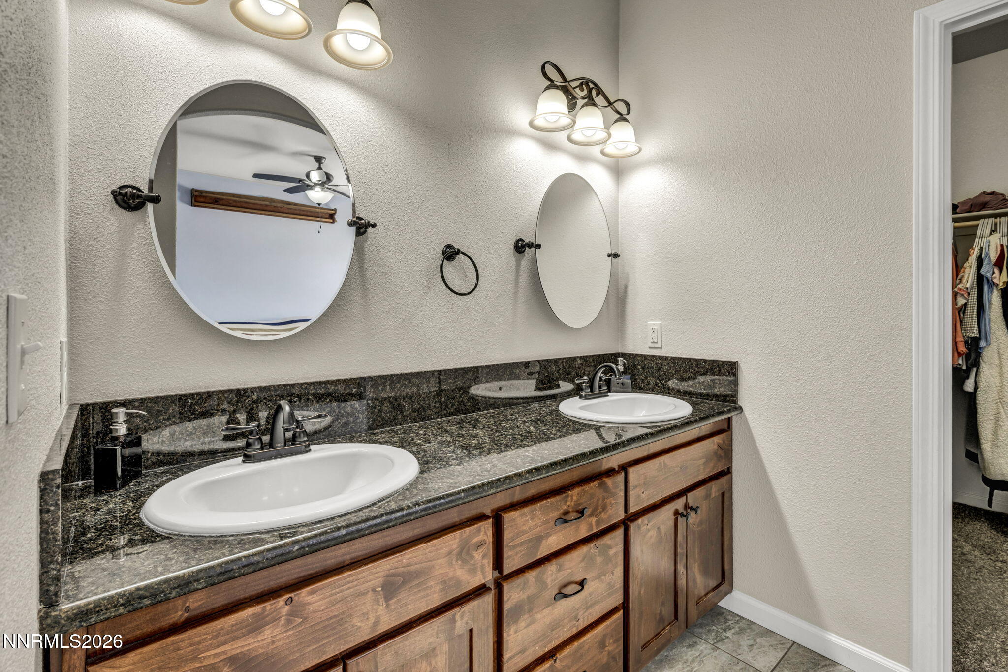 1286 Sky Ridge Drive Fallon, NV 89406 - Photo 24 of 49 a bathroom with a granite countertop double vanity sinks and a mirror