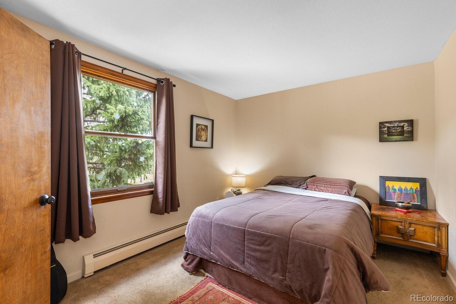 8600 South Warhawk Road Conifer, CO 80433 - Photo 12 of 50 a bedroom with a bed and a window