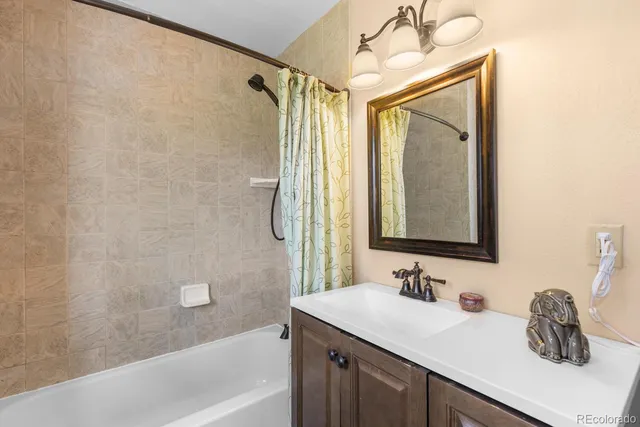 a bathroom with a granite countertop sink a mirror and a bathtub