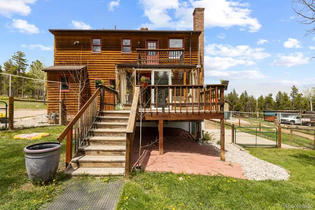 a view of a house with backyard and a trees