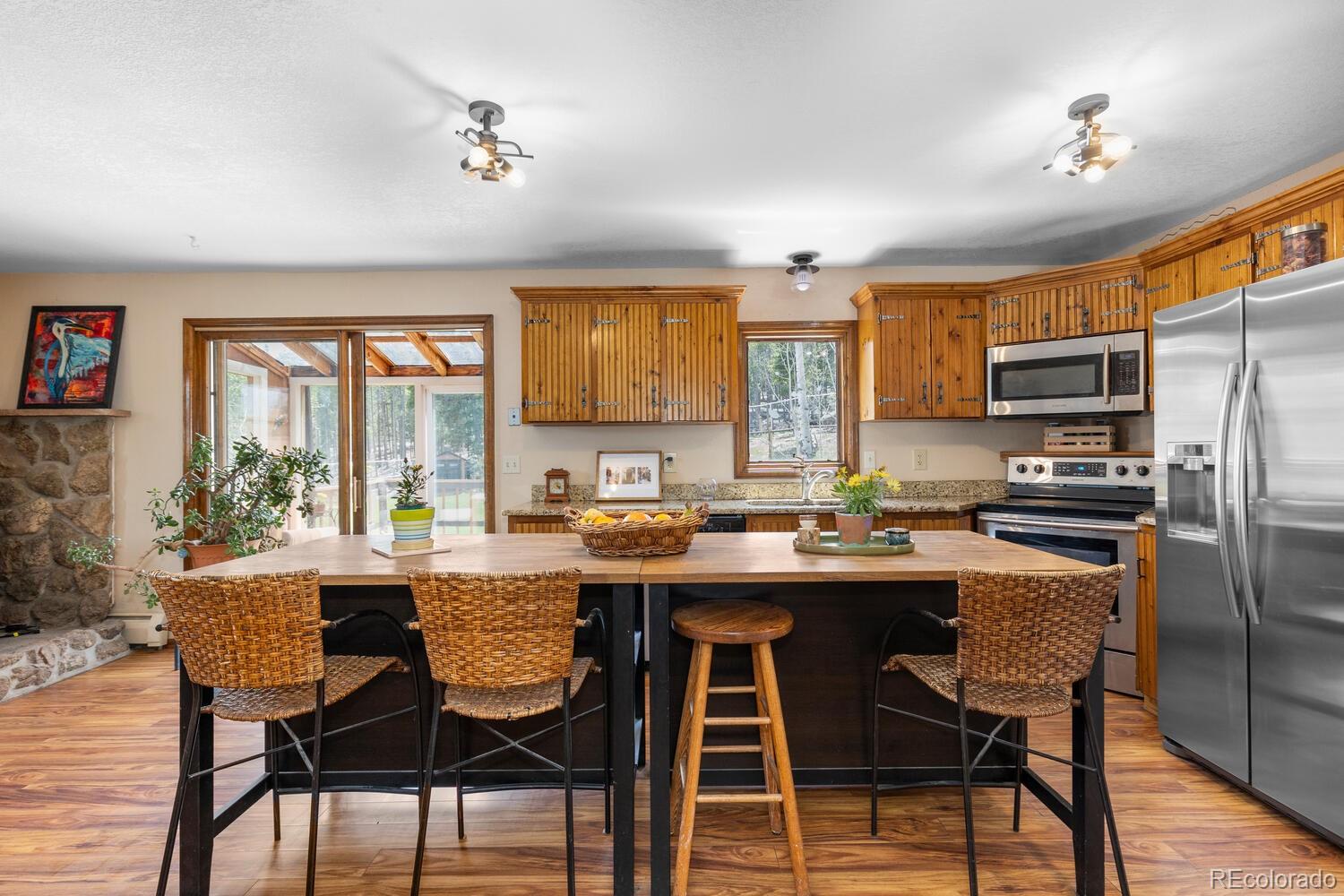 8600 South Warhawk Road Conifer, CO 80433 - Photo 5 of 50 a kitchen with a table chairs microwave and cabinets