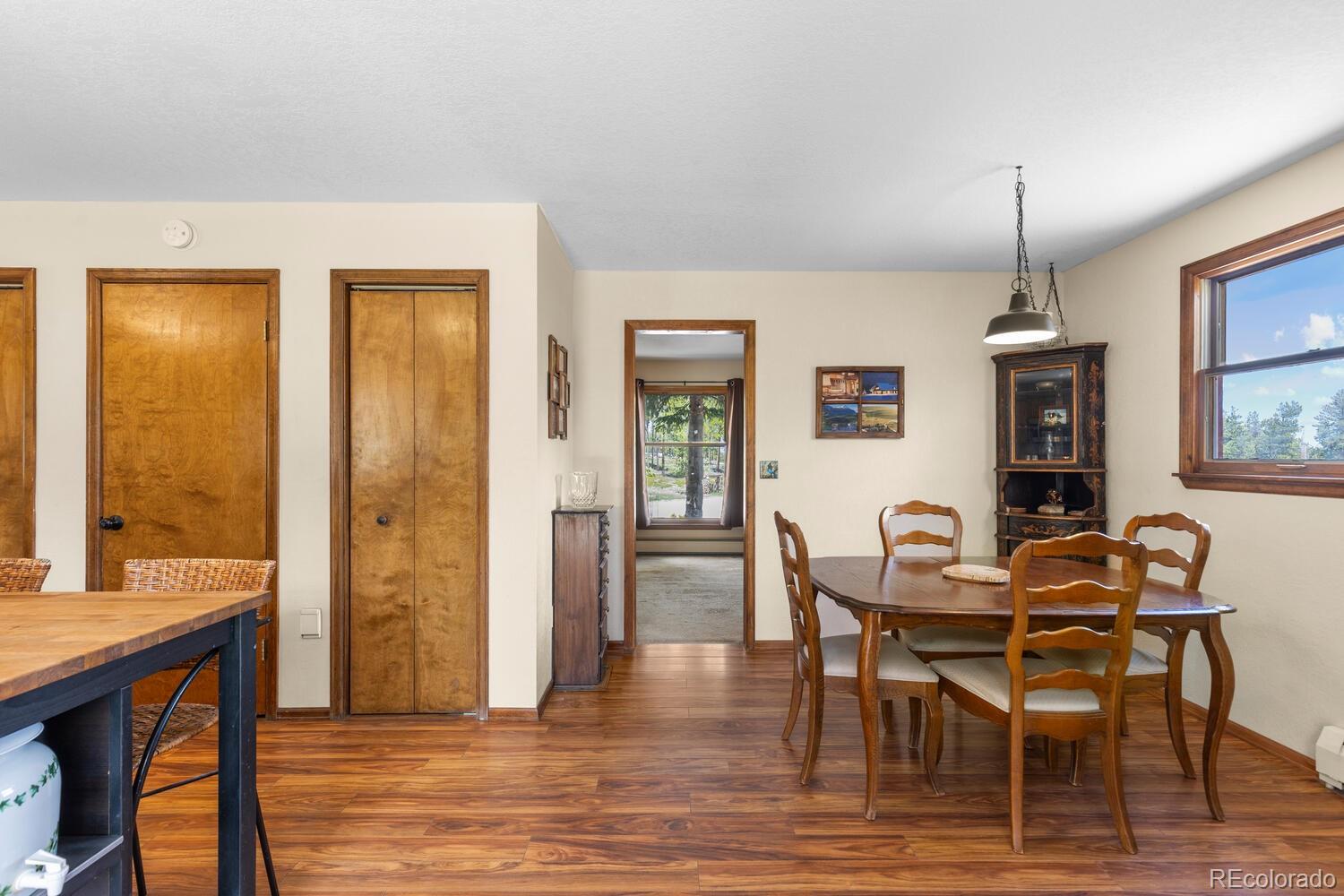 8600 South Warhawk Road Conifer, CO 80433 - Photo 9 of 50 a dining room with furniture window wooden floor