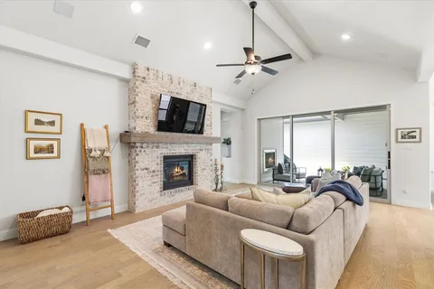 a living room with furniture a fireplace and a flat screen tv