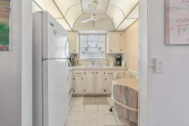 a kitchen with white cabinets and refrigerator