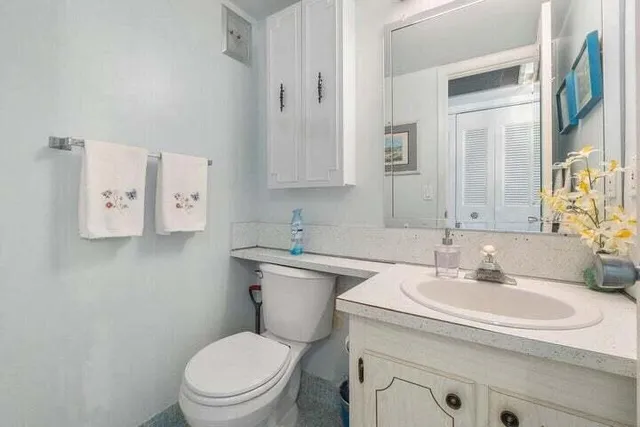 a bathroom with a toilet sink and mirror